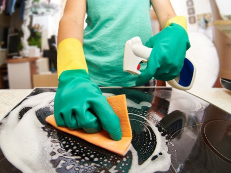 Professional office cleaner sanitizing shared workplace surfaces
